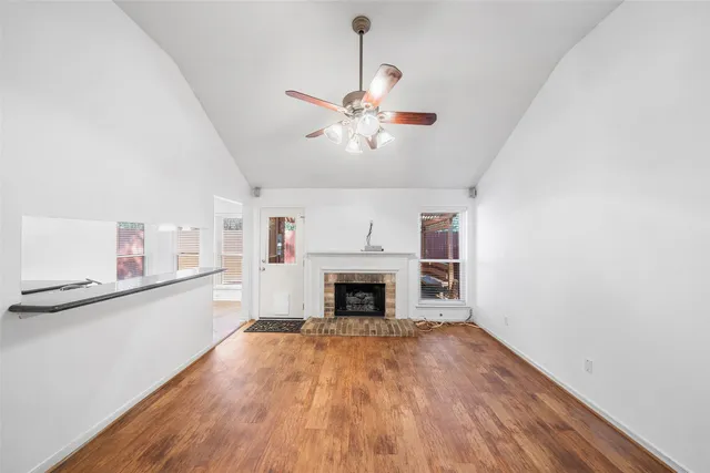 a view of a livingroom with a fireplace a chandelier and wooden floor