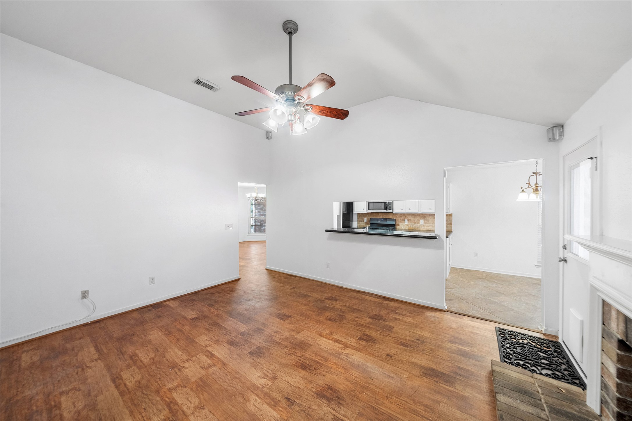 107 Sandpebble Drive The Woodlands, TX 77381 - Photo 5 of 30 a view of a room with a kitchen and a ceiling fan