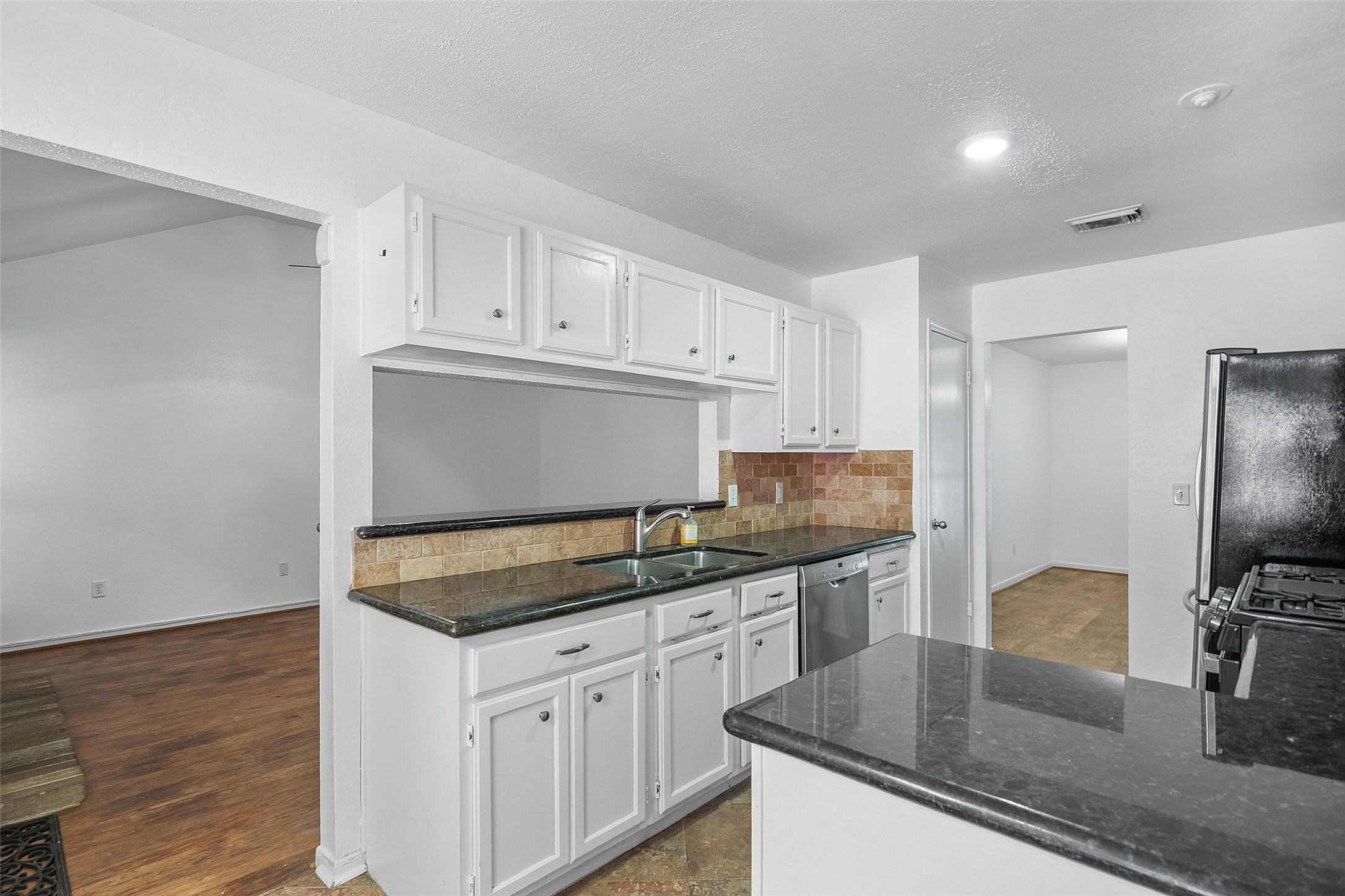 107 Sandpebble Drive The Woodlands, TX 77381 - Photo 7 of 30 a kitchen with granite countertop a sink and refrigerator