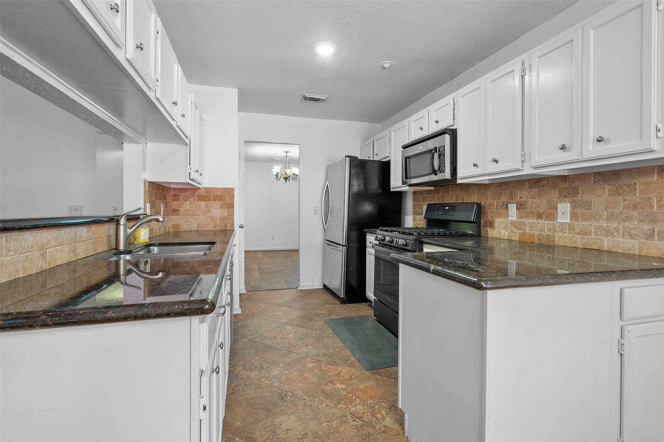 107 Sandpebble Drive The Woodlands, TX 77381 - Photo 10 of 30 a kitchen with stainless steel appliances granite countertop a sink stove and refrigerator
