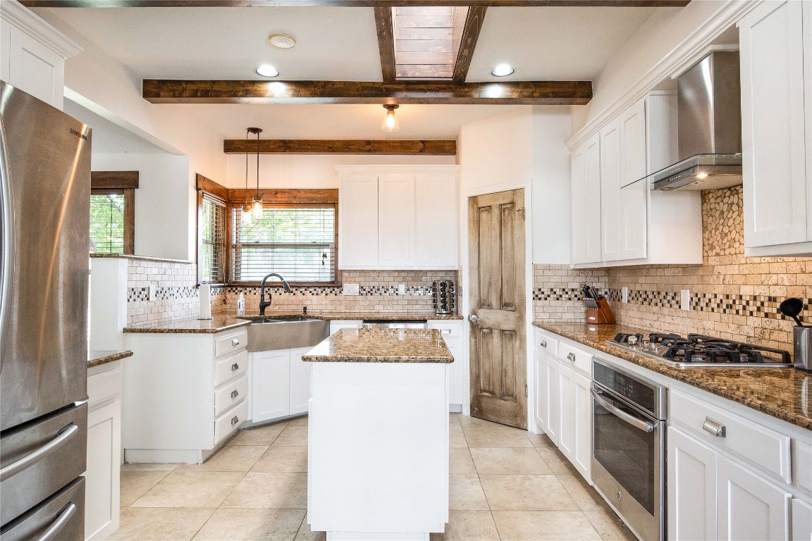 11209 Southwest Oaks Austin, TX 78737 - Photo 11 of 34 Kitchen with white cabinets, dark stone counters, wall chimney range hood, appliances with stainless steel finishes, and recessed lighting