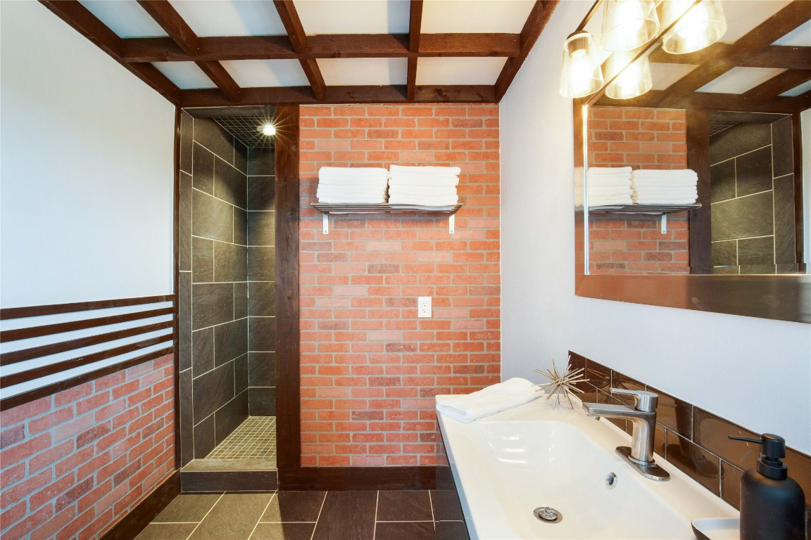 11209 Southwest Oaks Austin, TX 78737 - Photo 20 of 34 Full bathroom with coffered ceiling, brick wall, beam ceiling, a stall shower, and vanity