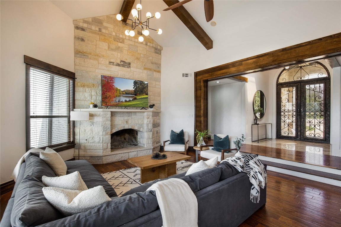 11209 Southwest Oaks Austin, TX 78737 - Photo 29 of 34 Living area with wood-type flooring, high vaulted ceiling, beamed ceiling, a fireplace, and french doors