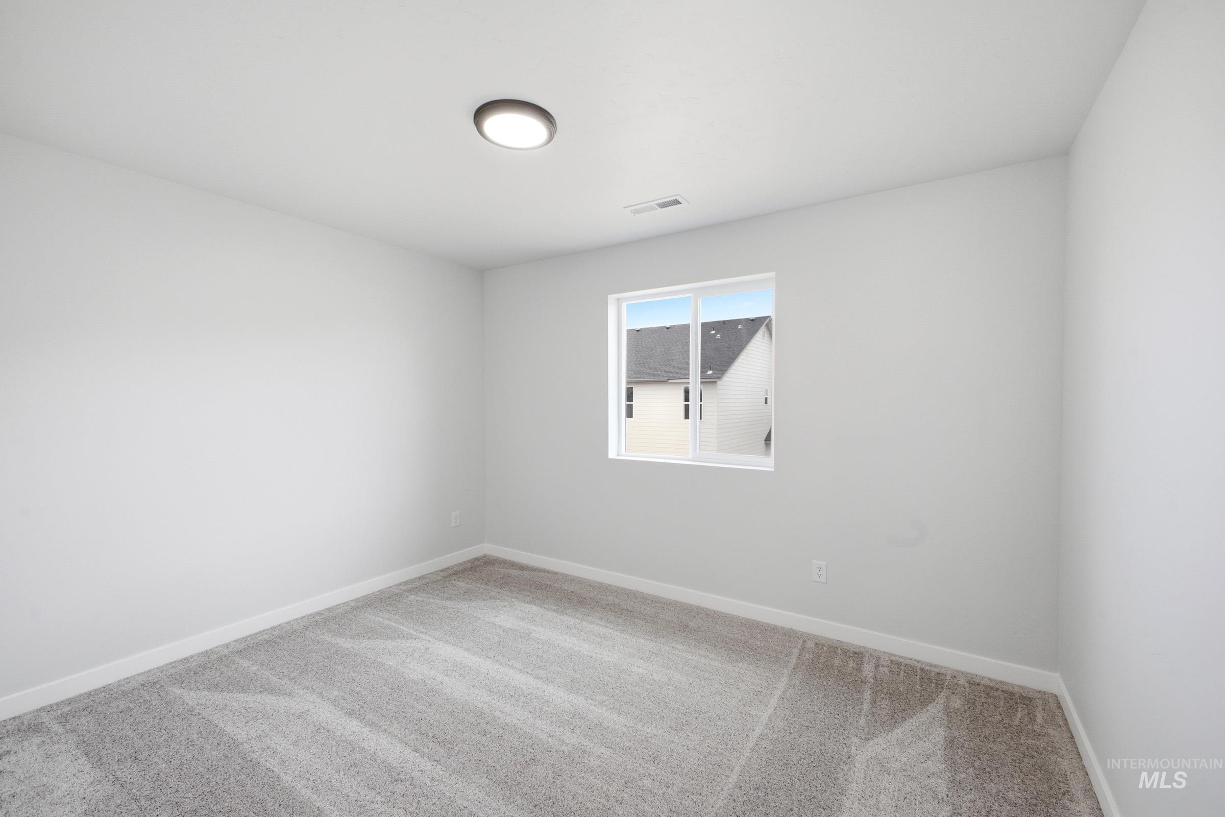 13718 Inman Court Caldwell, ID 83607 - Photo 14 of 20 Empty room featuring light colored carpet and baseboards