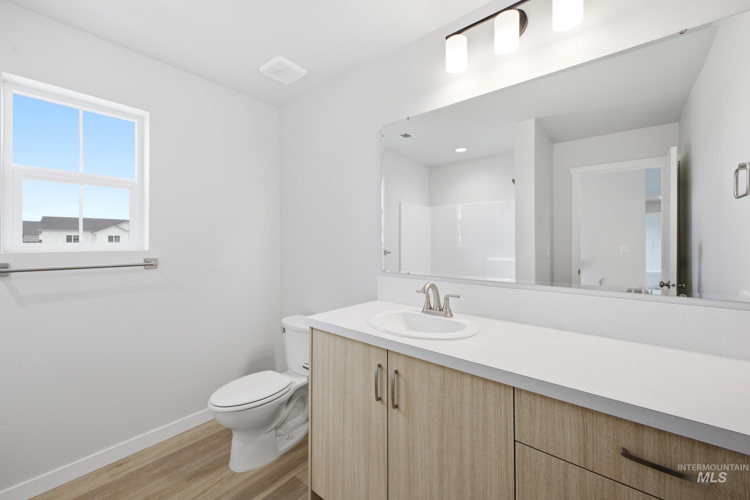 13718 Inman Court Caldwell, ID 83607 - Photo 15 of 20 Bathroom with vanity, light wood-style flooring, and a shower