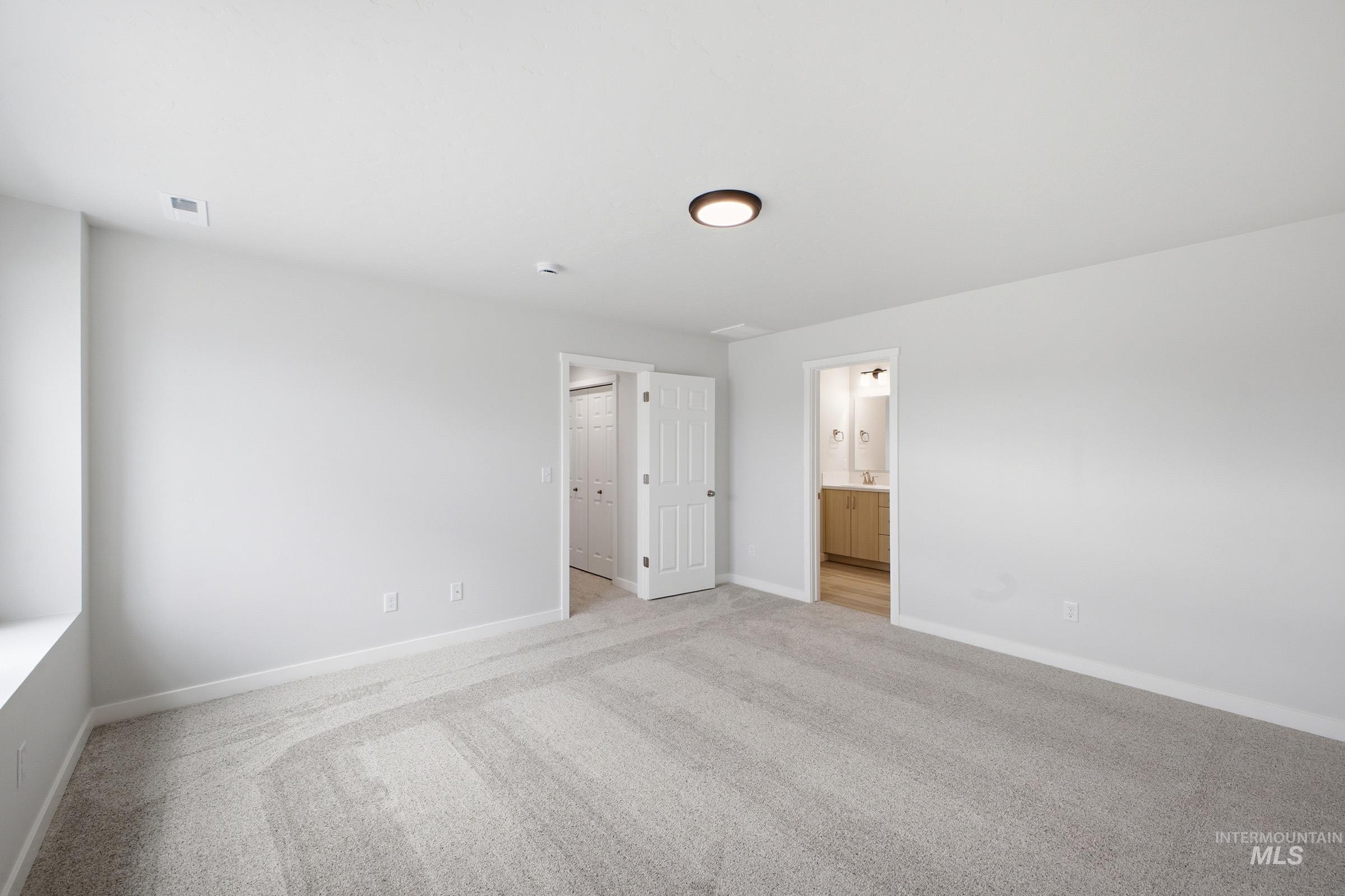 13718 Inman Court Caldwell, ID 83607 - Photo 18 of 20 Unfurnished bedroom featuring light carpet and connected bathroom