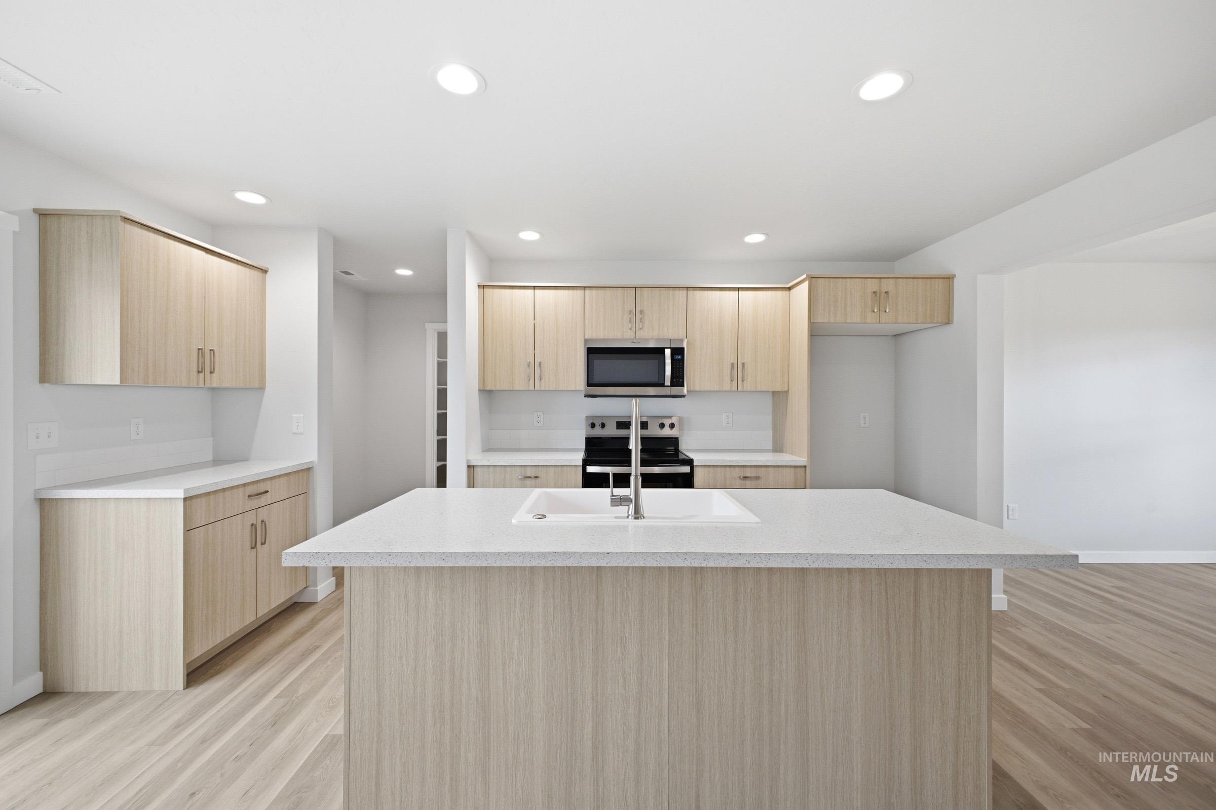 13718 Inman Court Caldwell, ID 83607 - Photo 4 of 20 Kitchen with stainless steel appliances, light wood-type flooring, light wood finish cabinets, and recessed lighting