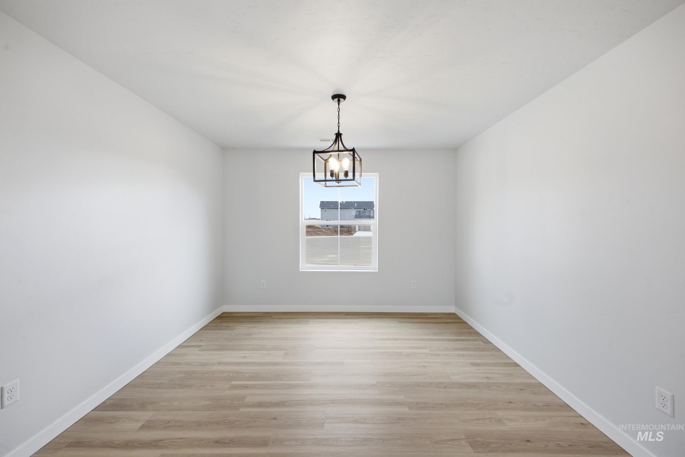 13718 Inman Court Caldwell, ID 83607 - Photo 10 of 20 Unfurnished dining area with light wood-style floors and suspended lighting