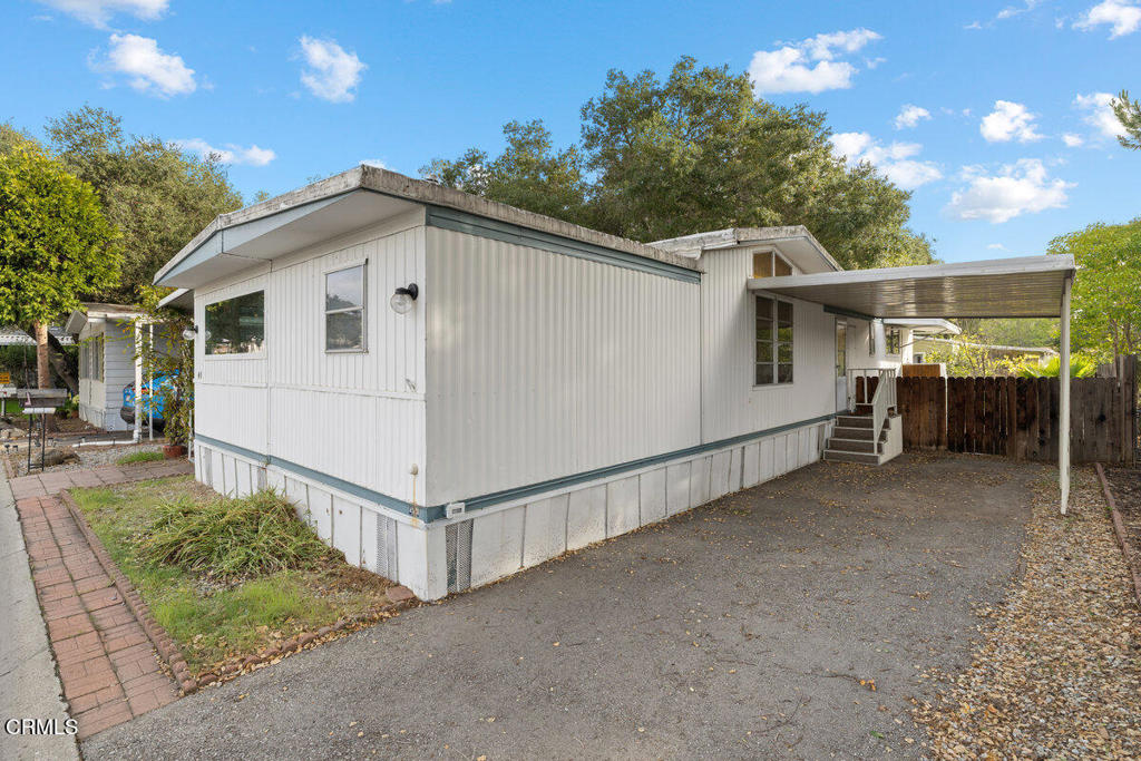 1225 South Rice Road, Unit 41 Ojai, CA 93023 - Photo 33 of 38 a view of a white house with a large tree and wooden fence