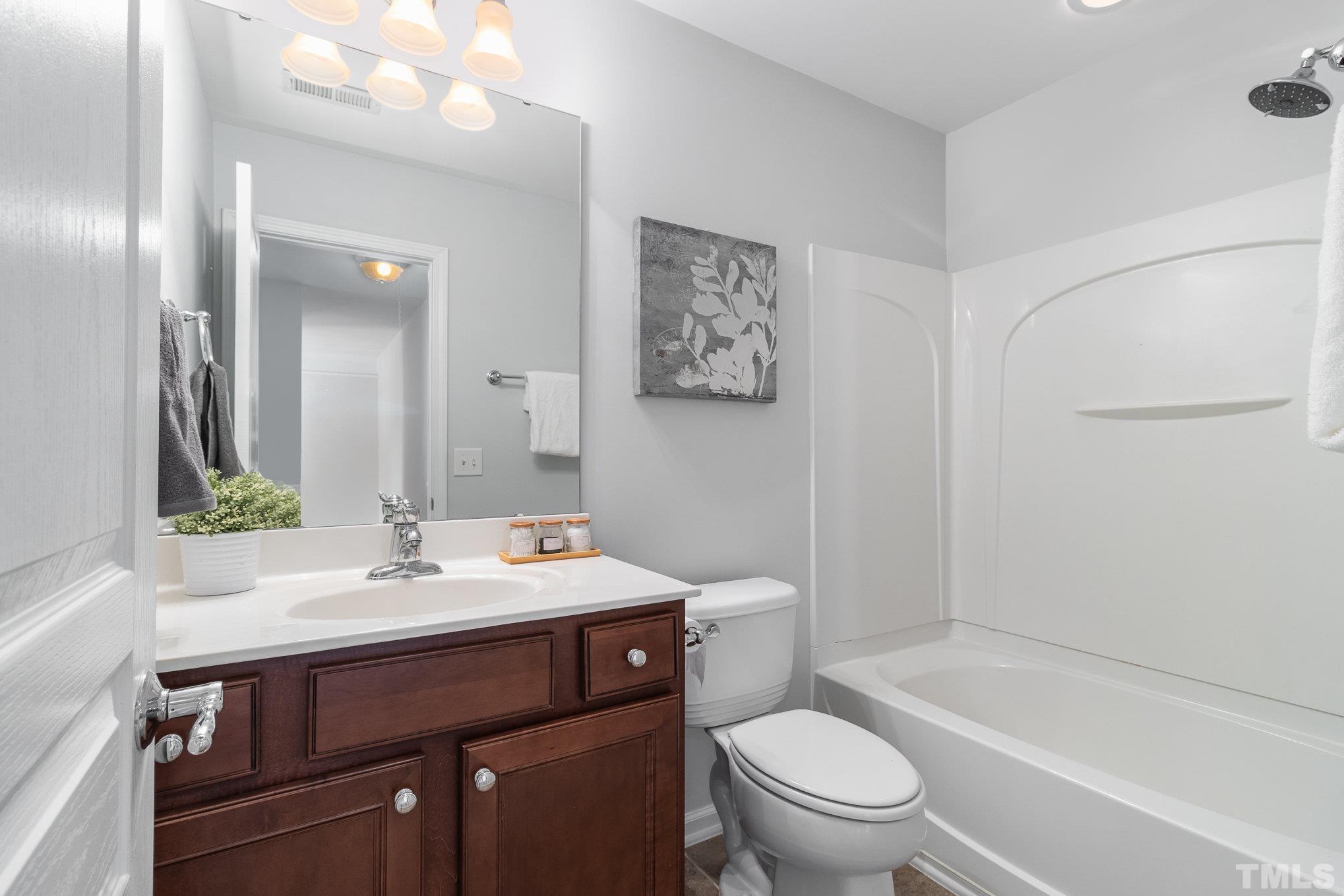 8220 Pilots View Drive Raleigh, NC 27617 - Photo 17 of 20 a bathroom with a sink a toilet and a large mirror