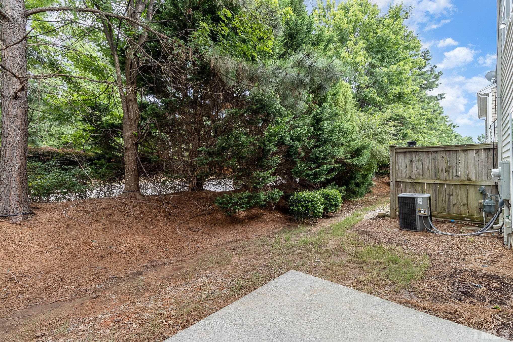 8220 Pilots View Drive Raleigh, NC 27617 - Photo 19 of 20 a view of a backyard with large trees and wooden fence