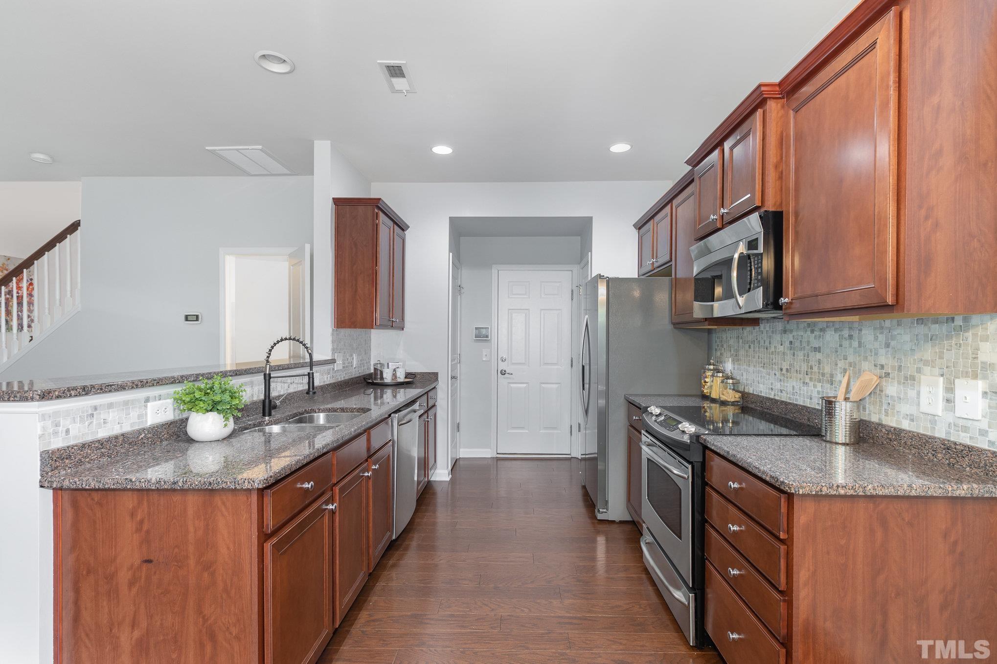 8220 Pilots View Drive Raleigh, NC 27617 - Photo 6 of 20 a kitchen with stainless steel appliances granite countertop a sink stove and refrigerator