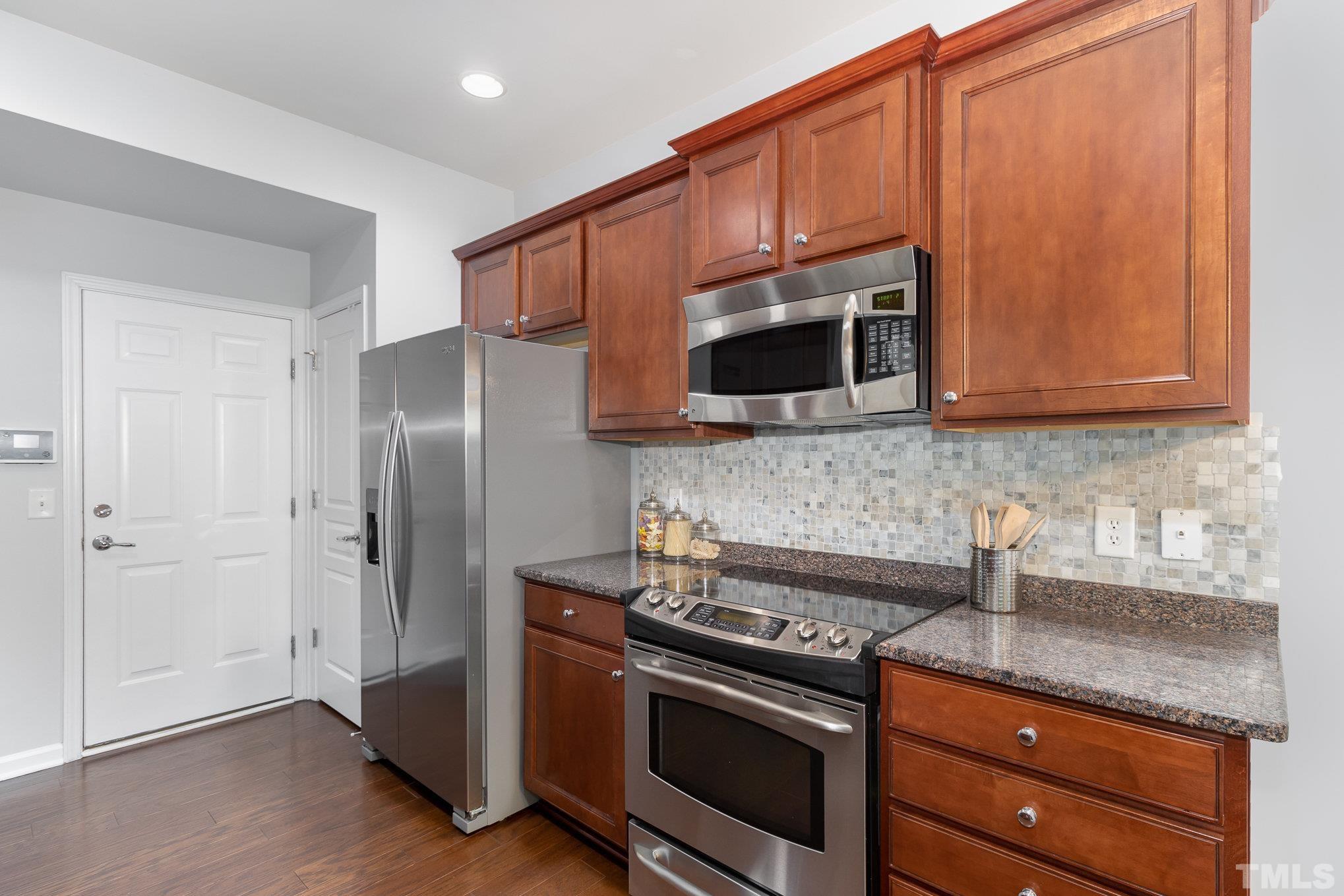 8220 Pilots View Drive Raleigh, NC 27617 - Photo 7 of 20 a kitchen with stainless steel appliances granite countertop a refrigerator stove and microwave