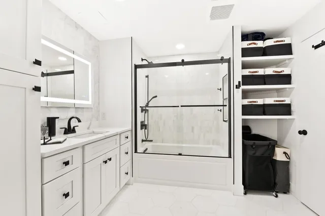 a bathroom with a double vanity sink a mirror and shower