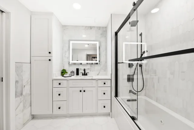 a bathroom with a bathtub sink and mirror