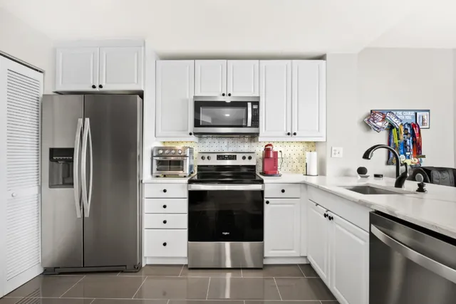 a kitchen with cabinets stainless steel appliances and a counter space