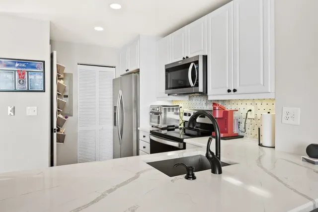 a view of a kitchen with a sink and refrigerator
