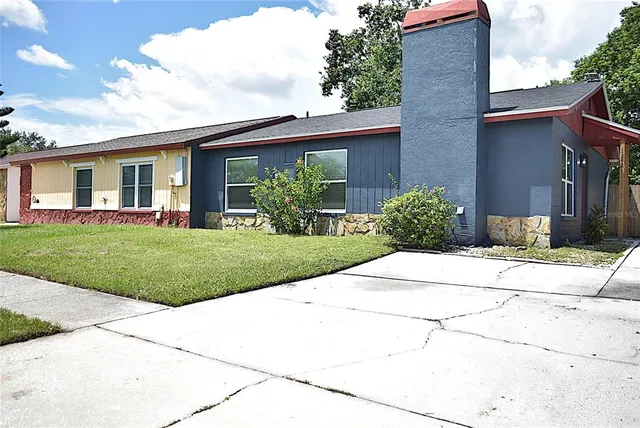 a front view of a house with a yard and potted plants