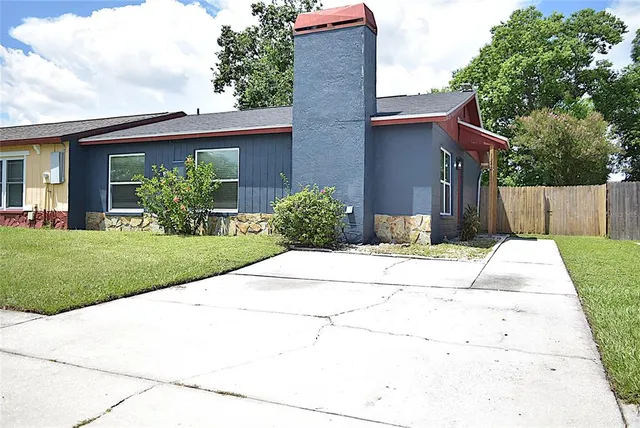 a front view of a house with a yard and potted plants