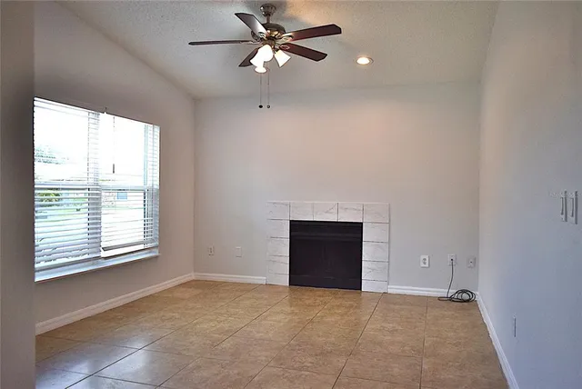 an empty room with fan and windows