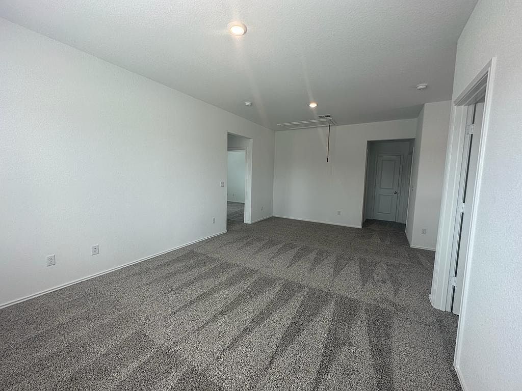 160 River Rise Road Kyle, TX 78640 - Photo 6 of 35 Spacious interior room featuring light gray carpeting, neutral wall paint, recessed lighting, and white baseboards