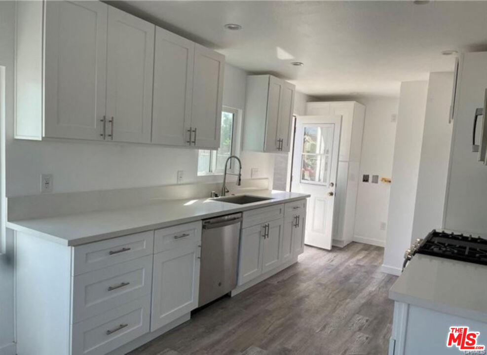 328 West Elm Street Compton, CA 90220 - Photo 4 of 12 a kitchen with white cabinets and sink