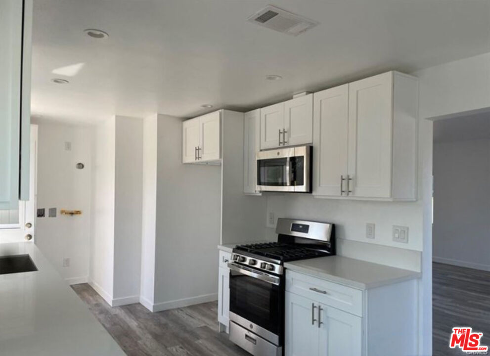 328 West Elm Street Compton, CA 90220 - Photo 5 of 12 a kitchen with stainless steel appliances granite countertop white cabinets and a stove