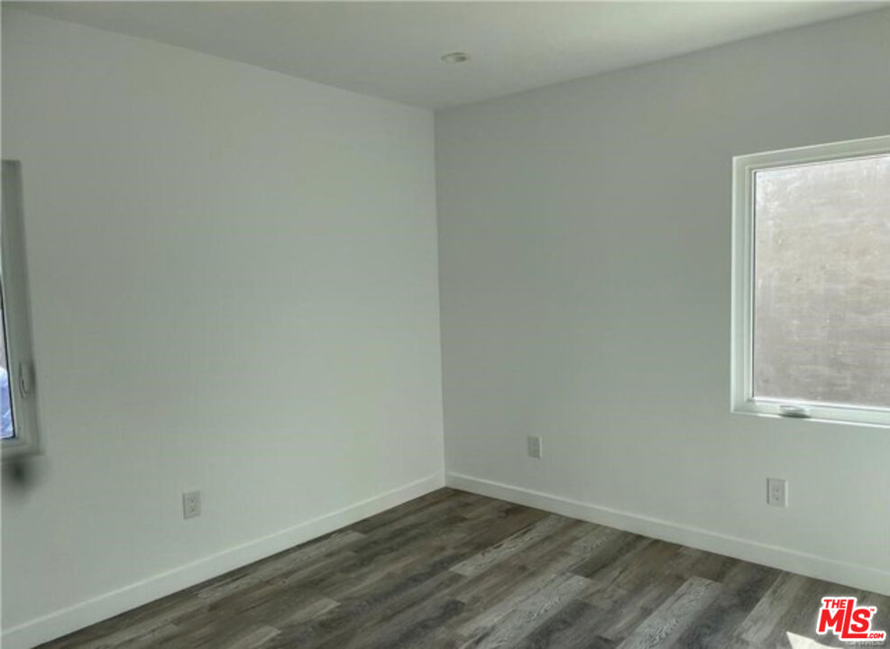 328 West Elm Street Compton, CA 90220 - Photo 7 of 12 a view of an empty room with wooden floor and a window