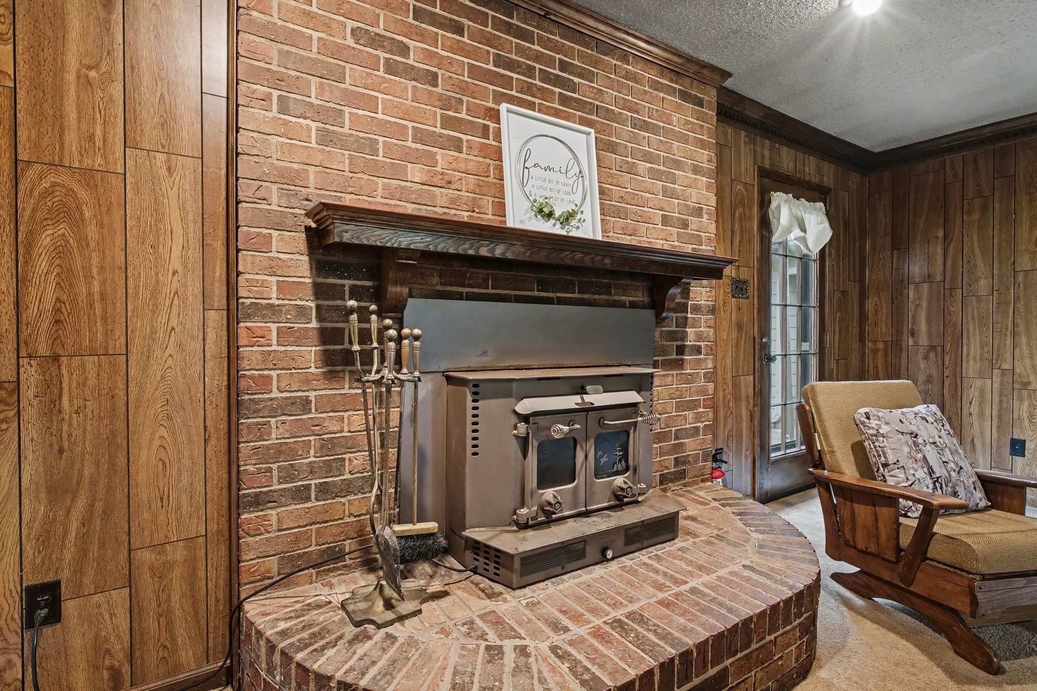 11380 Sycamore Farms Road Collierville, TN 38017 - Photo 14 of 38 Sitting room with wooden walls, a textured ceiling, a fireplace, carpet floors, and crown molding