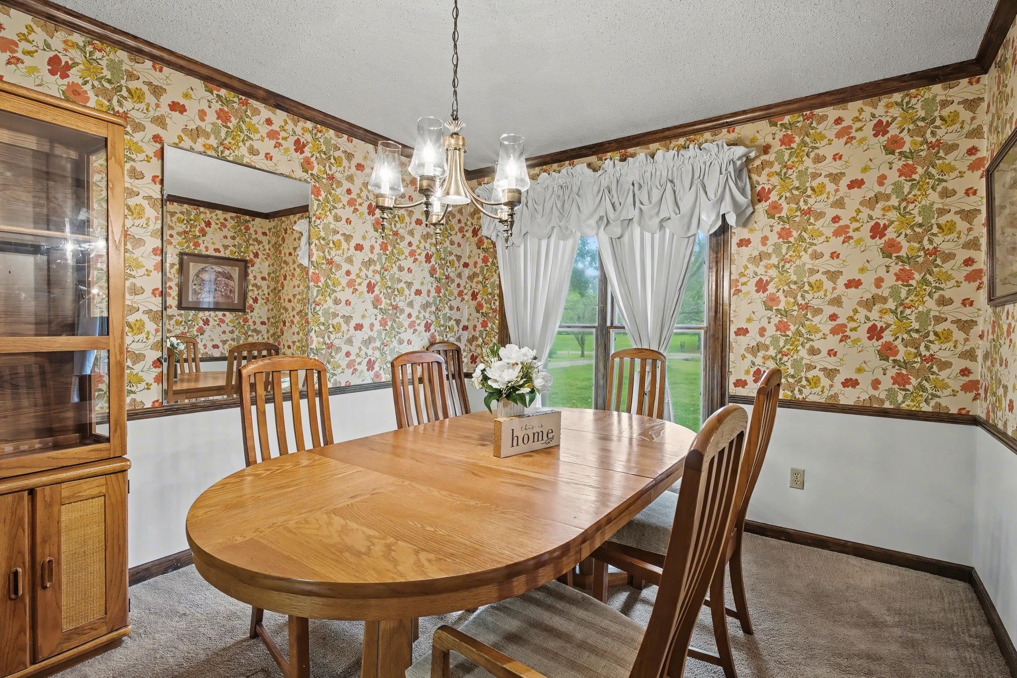 11380 Sycamore Farms Road Collierville, TN 38017 - Photo 15 of 38 Carpeted dining area featuring a textured ceiling, a chandelier, wallpapered walls, ornamental molding, and wainscoting