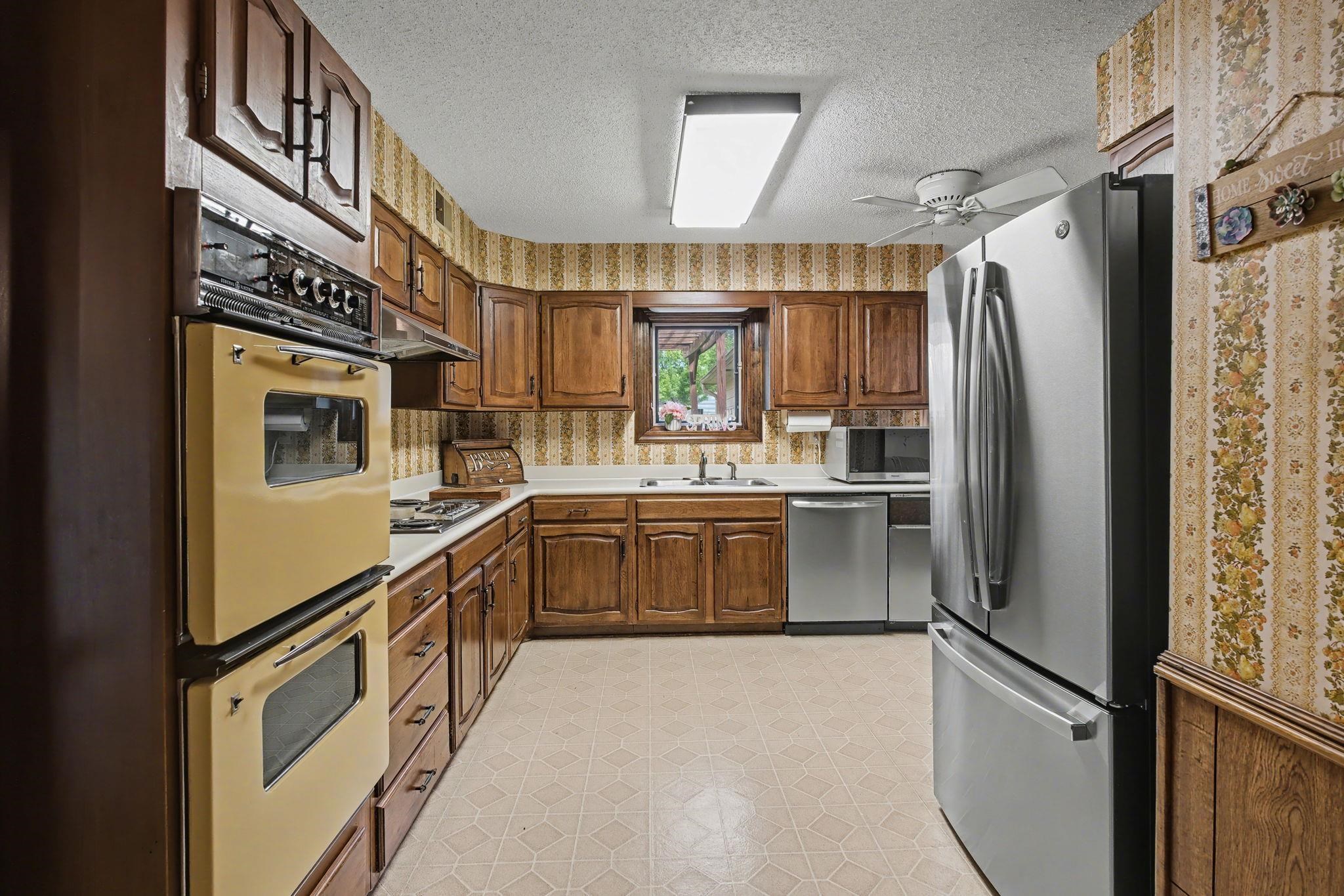 11380 Sycamore Farms Road Collierville, TN 38017 - Photo 16 of 38 Kitchen featuring stainless steel appliances, light floors, light countertops, a textured ceiling, and ceiling fan