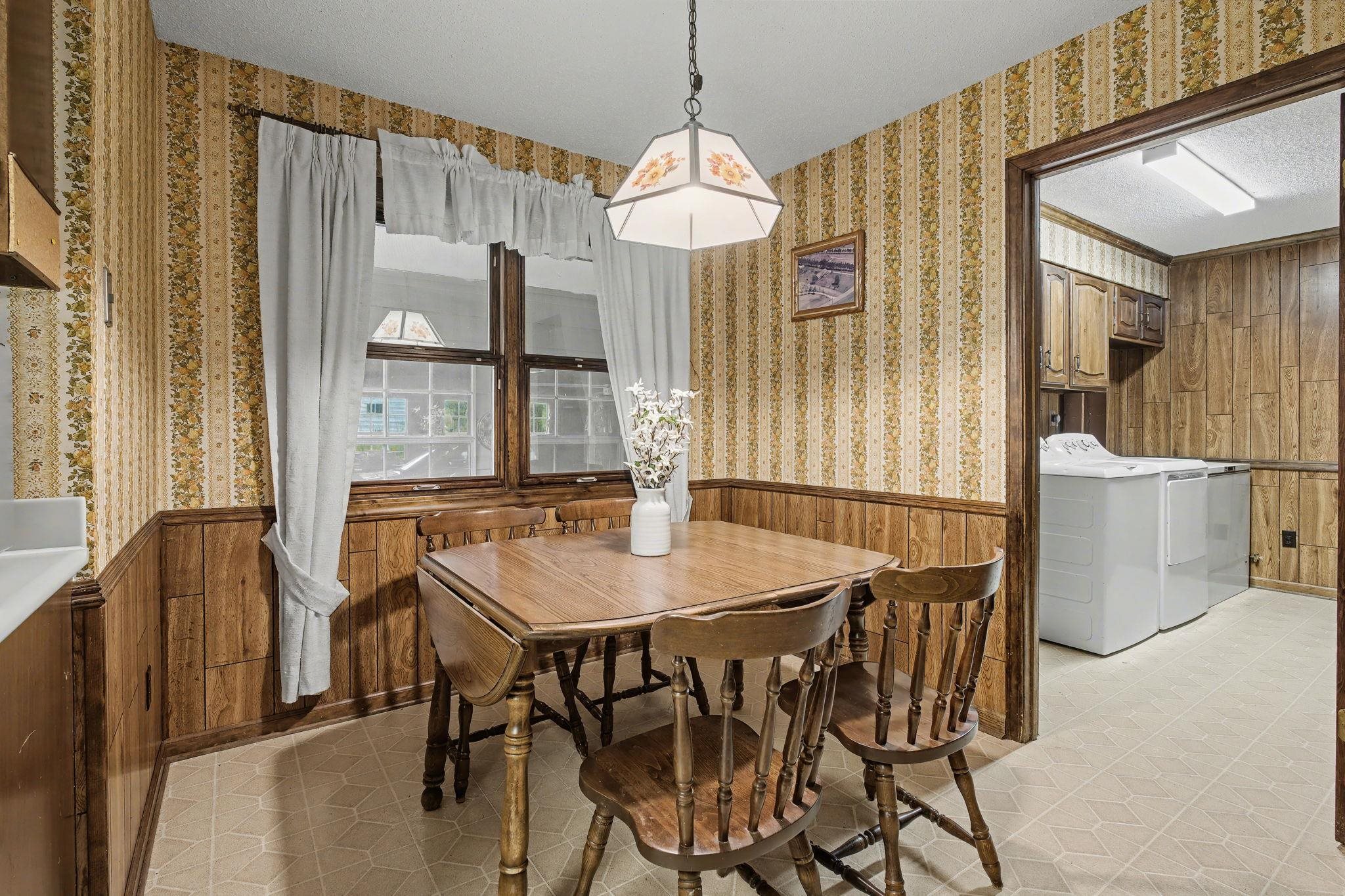 11380 Sycamore Farms Road Collierville, TN 38017 - Photo 18 of 38 Dining area with wood walls, light flooring, a textured ceiling, and washing machine and clothes dryer