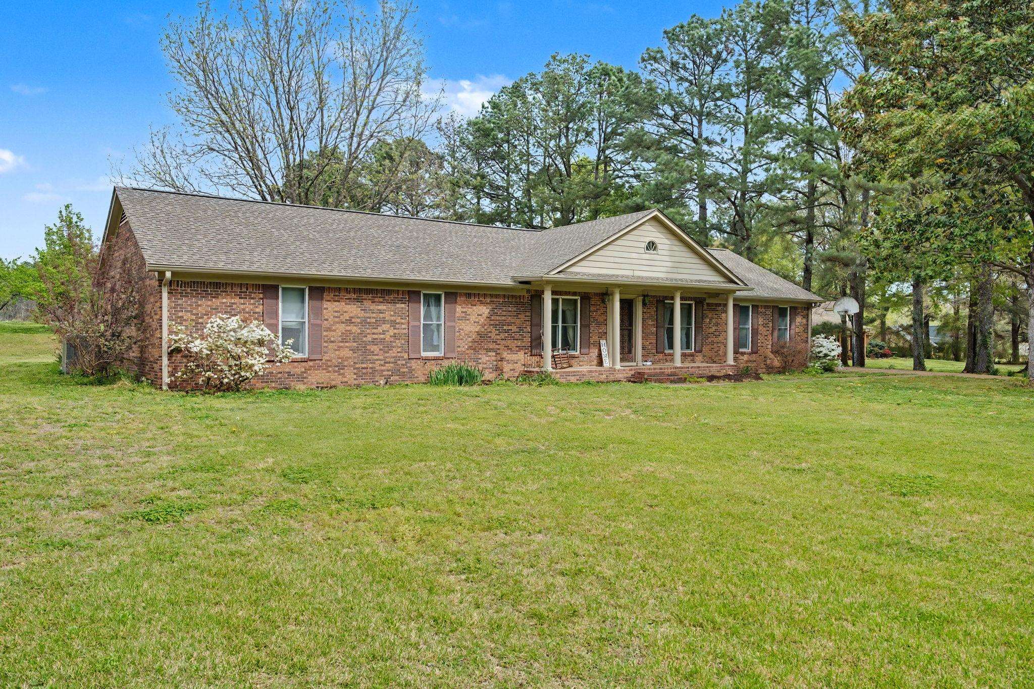 11380 Sycamore Farms Road Collierville, TN 38017 - Photo 2 of 38 Ranch-style house featuring covered porch, a front lawn, a shingled roof, and brick siding
