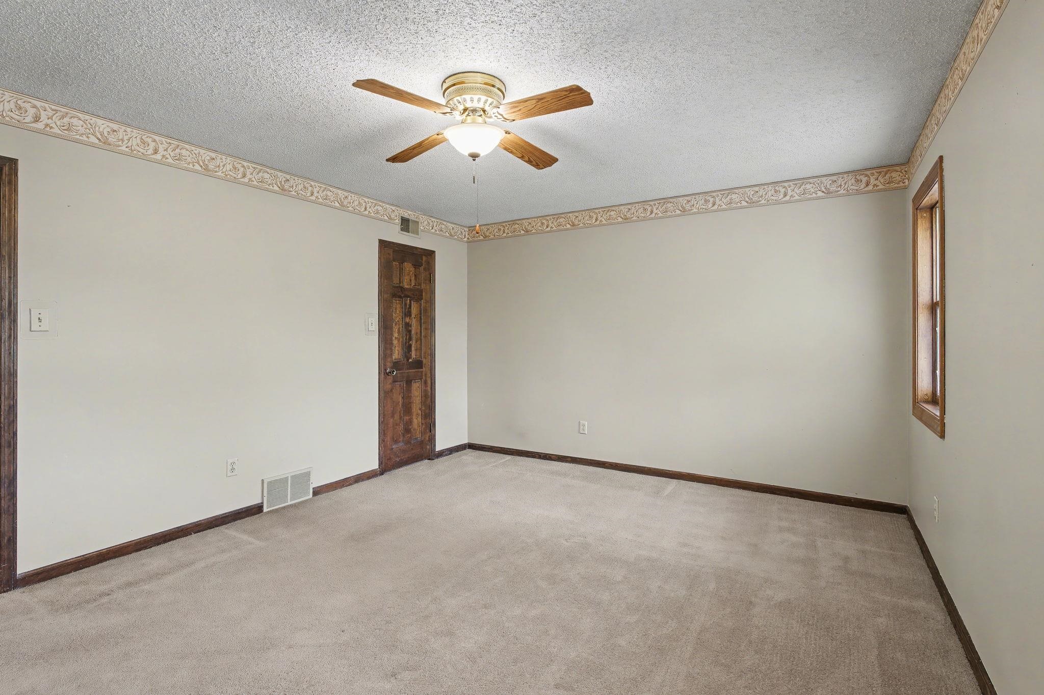 11380 Sycamore Farms Road Collierville, TN 38017 - Photo 25 of 38 Unfurnished room with ceiling fan, light colored carpet, and a textured ceiling