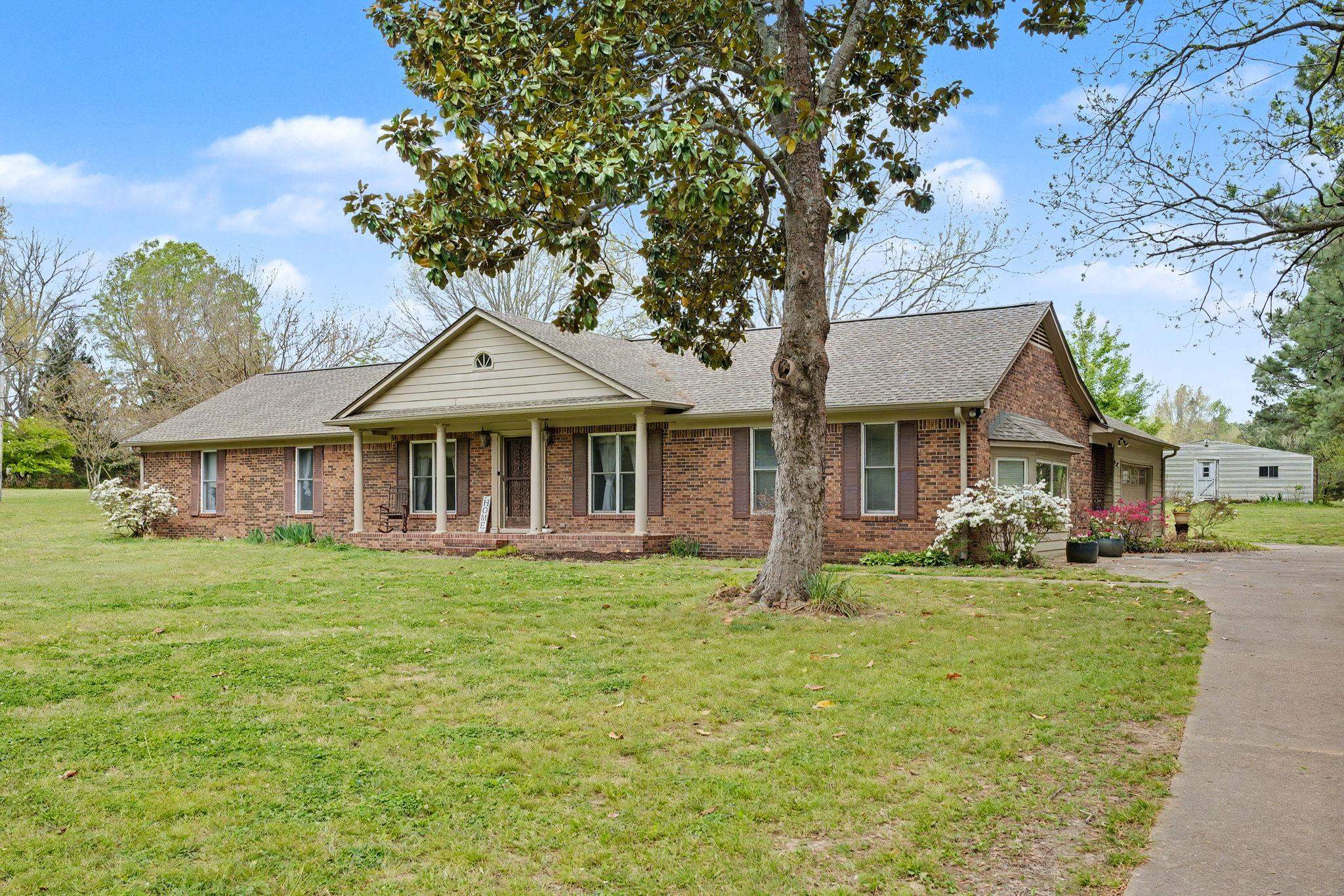 11380 Sycamore Farms Road Collierville, TN 38017 - Photo 3 of 38 View of front facade with a front lawn, covered porch, roof with shingles, and brick siding
