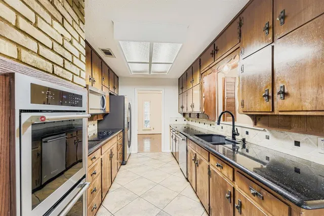 a kitchen with stainless steel appliances granite countertop a sink and a stove