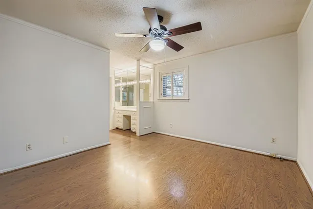 an empty room with a window and a ceiling fan