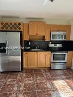 a kitchen with stainless steel appliances granite countertop a stove a microwave and a refrigerator