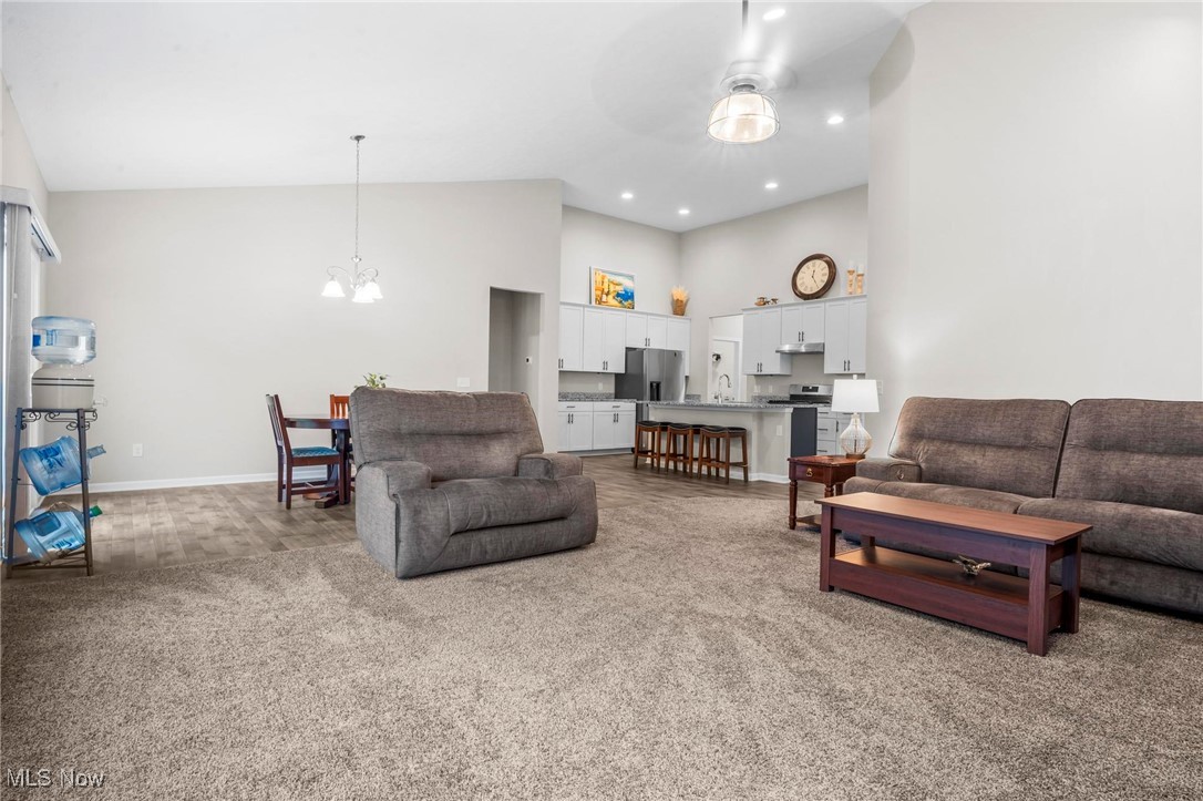 6824 Hatching Way North Ridgeville, OH 44039 - Photo 12 of 42 Living room with light carpet, high vaulted ceiling, sink, and ceiling fan with notable chandelier