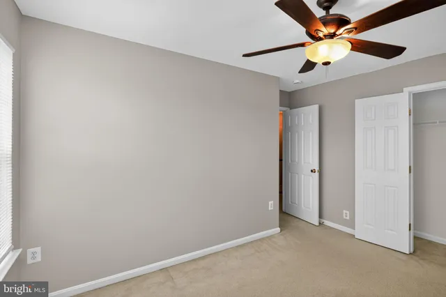 an empty room with a window and a fan