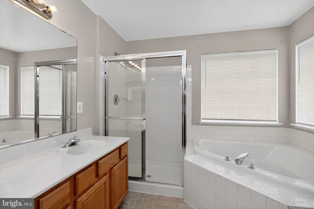 a bathroom with a tub a sink and mirror