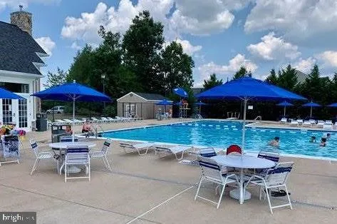 a view of a table and chairs under an umbrella in patio with a yard