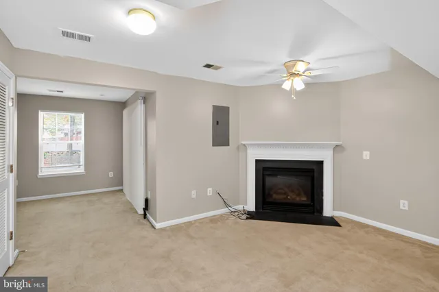 an empty room with a fireplace and fan