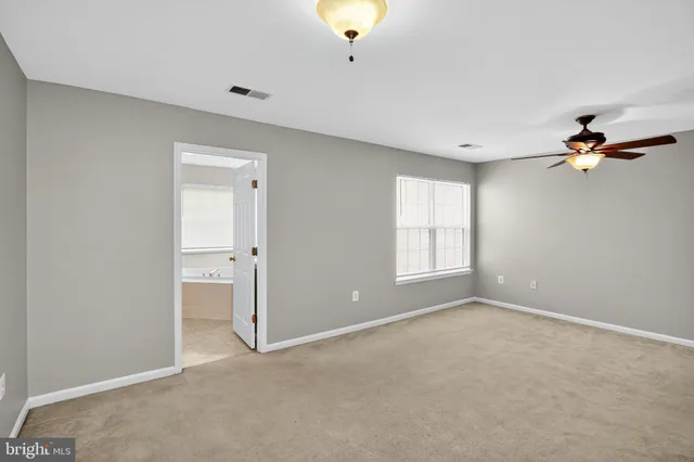 a view of a room with a ceiling fan and window