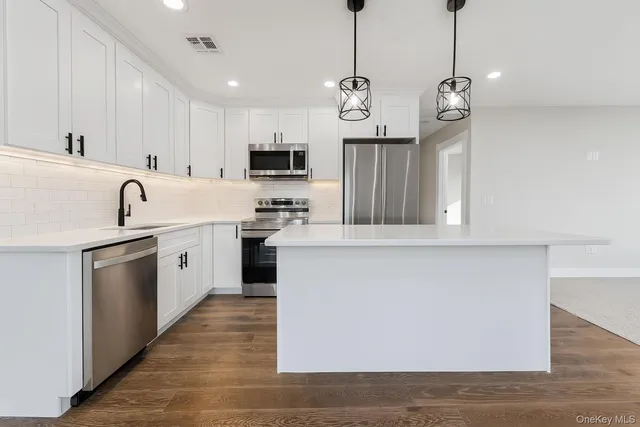 a kitchen with stainless steel appliances granite countertop a sink a stove and a refrigerator