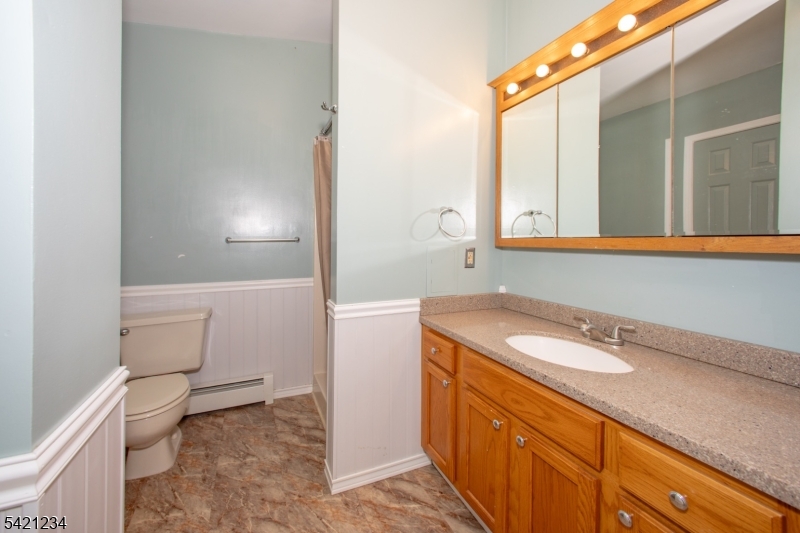 105 Valley Road Wantage, NJ 07461 - Photo 18 of 32 a bathroom with a granite countertop sink a toilet and a mirror