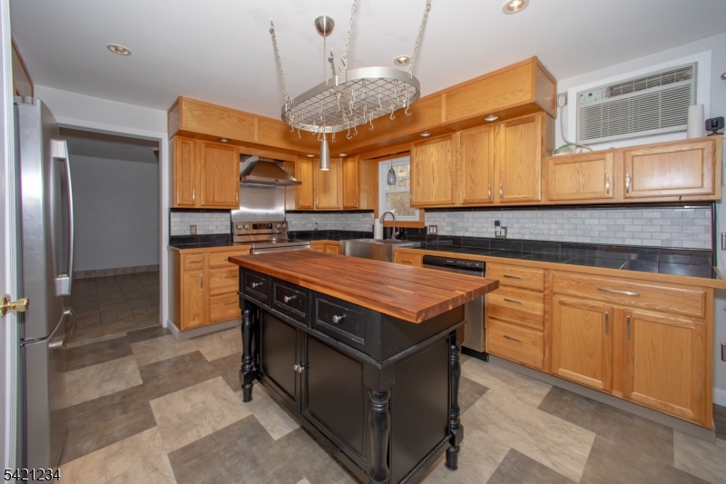 105 Valley Road Wantage, NJ 07461 - Photo 7 of 32 a kitchen with stainless steel appliances granite countertop a stove a sink and a refrigerator