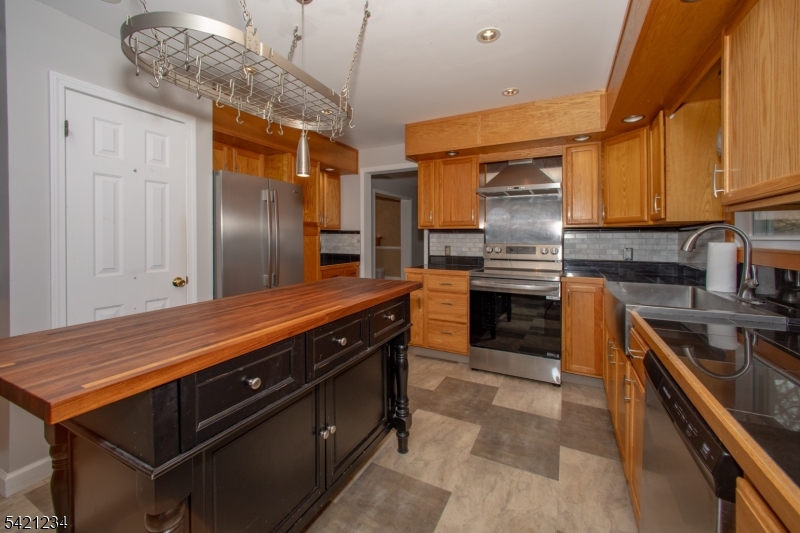 105 Valley Road Wantage, NJ 07461 - Photo 8 of 32 a kitchen with stainless steel appliances granite countertop a stove refrigerator and cabinets