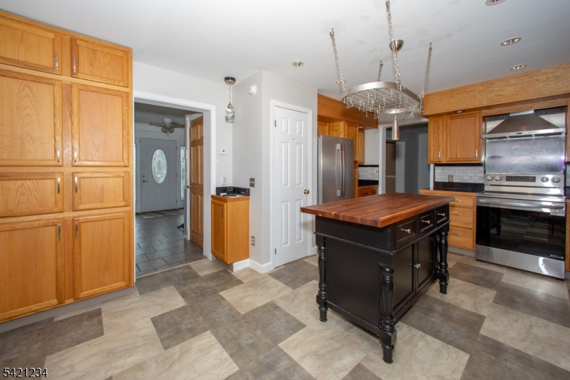 105 Valley Road Wantage, NJ 07461 - Photo 10 of 32 a kitchen with stainless steel appliances granite countertop a stove a refrigerator and a wooden cabinets