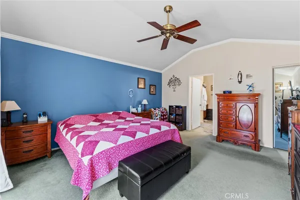 a bedroom with a bed a chandelier and dresser